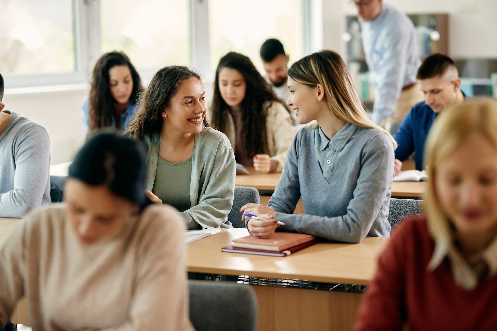 Happy female students talking during a class at the university.