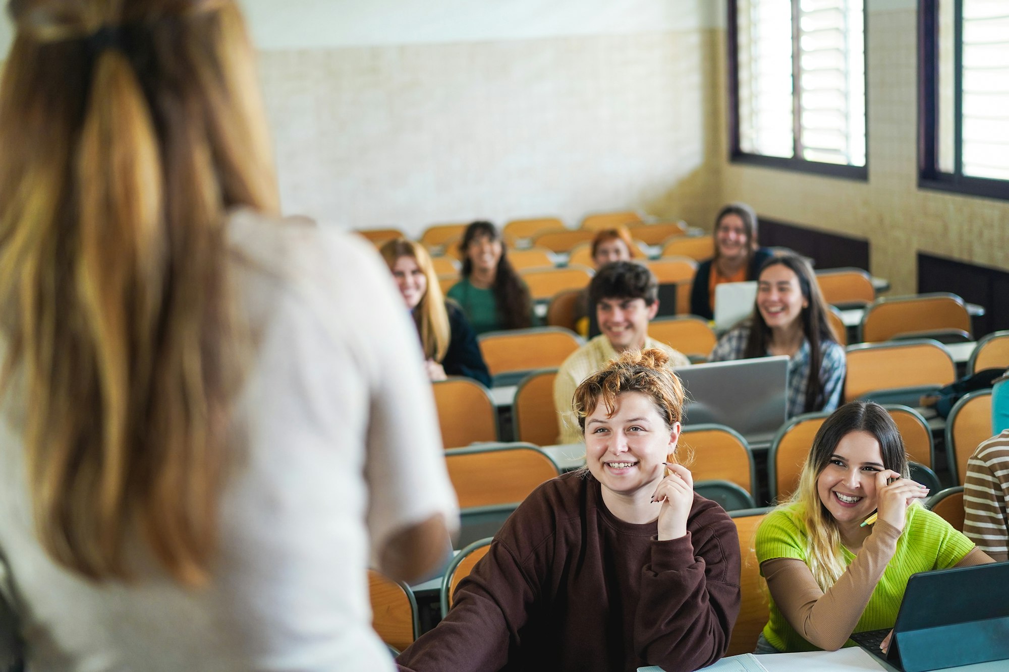 Mature teacher working with students inside classroom at school university