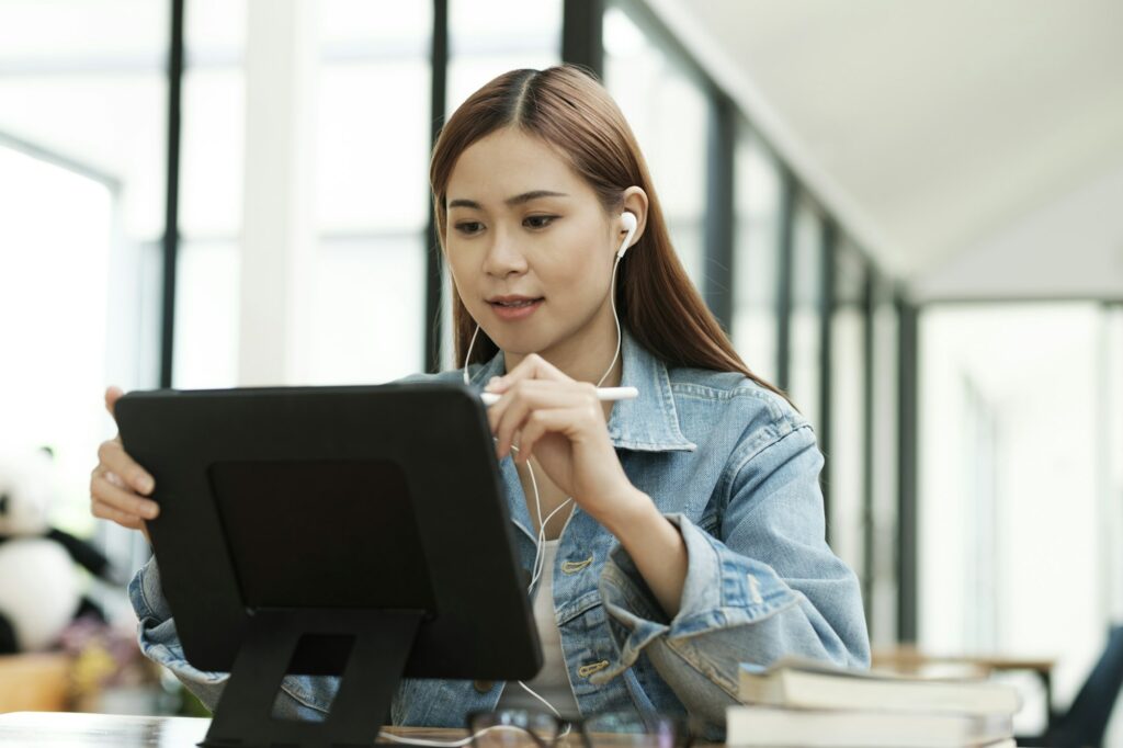 Young female student learning online using tablet.