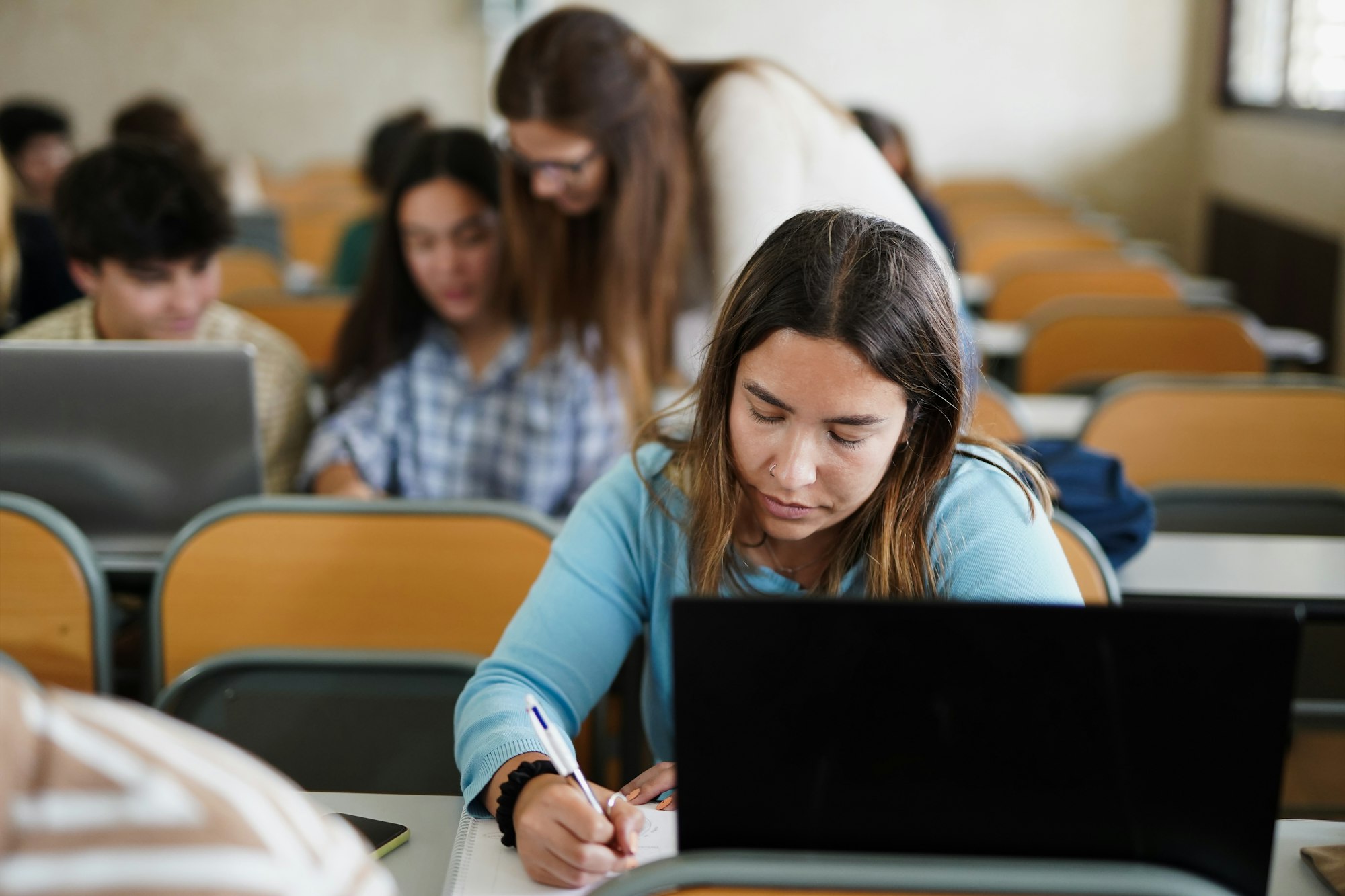 Young students learing inside university class room